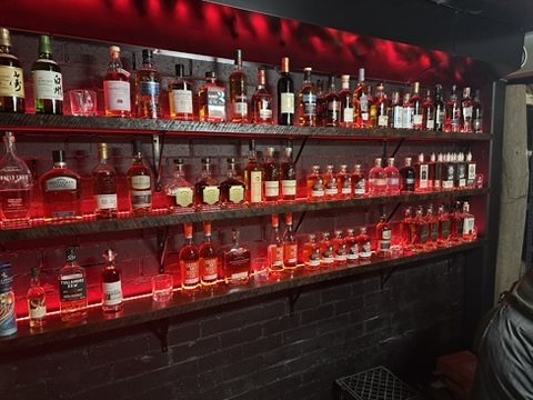Whisky bottles on red-lit shelves
